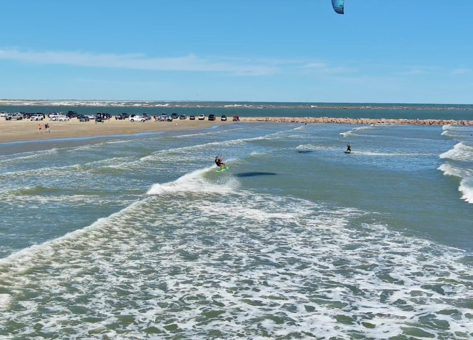 Kite surfer catching air over the Gulf off Port Aransas, Texas — turquoise water and a brightly colored kite mid-flight